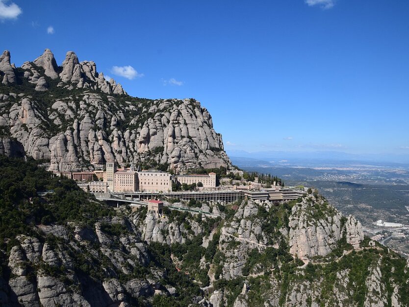 Sommerreise Partyurlaub in Lloret de Mar, Calella oder Malgrat in Spanien Drohnenaufnahme vom Kloster Montserrat und die Berge mit Aussicht in die Stadt