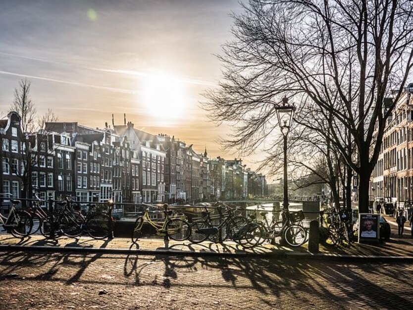 Fahrräder auf Brücke an Kanal, gutes Wetter Amsterdam