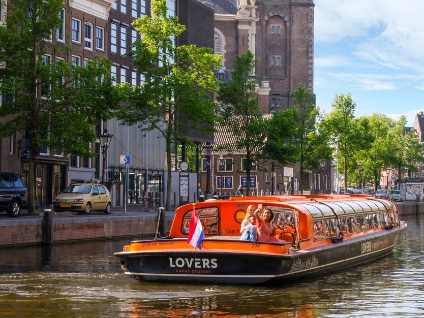 Lovers Canal Cruises Boot in Gracht vor einer Kirche