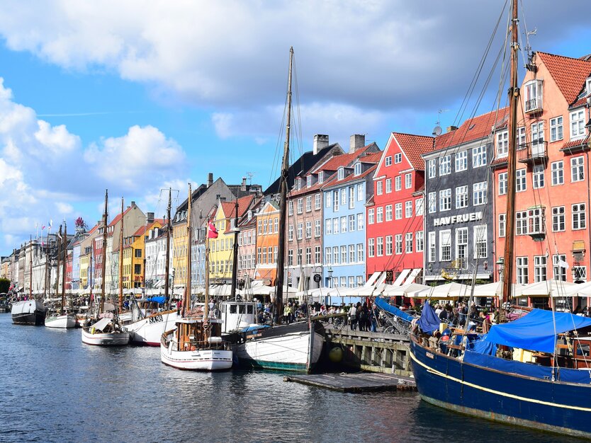 Städtetrip Kopenhagen, Hafen Boote, bunte Häuser, Promenade, blauer Himmel, Nyhavn
