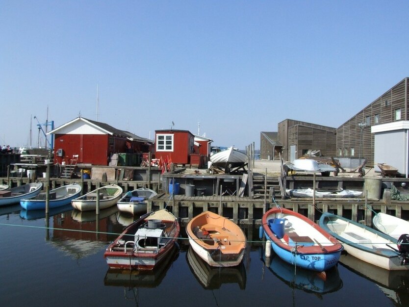 Städtereise Kopenhagen, Tagesausflug in die dänische Stadt Roskilde, kleiner Hafen mit Booten, rotes Häuschen, blauer Himmel, Strand, gutes Wetter