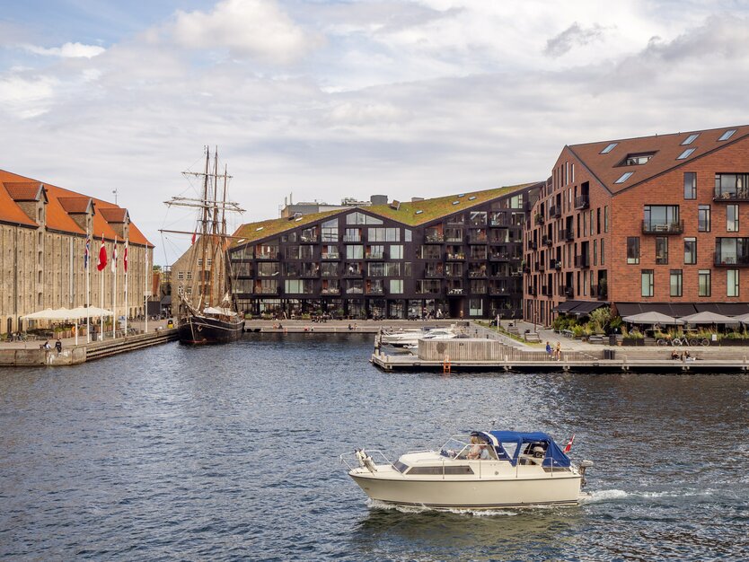 Städtereise Kopenhagen, Tagesausflug in die dänische Stadt Roskilde, Boot auf dem Wasser vor Wohnhäusern, Architektur, altes Segelboot