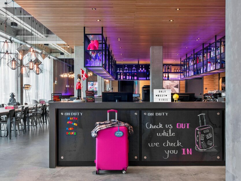 St&auml;dtereise Kopenhagen, Kopenhagen Hotel Moxy, moderne Rezeption und Lobby, pinker Koffer