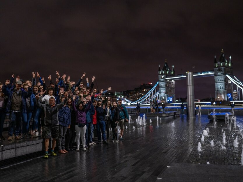 London Silvesterreise, MANGO Tours Gruppenfoto an der Promenade der Themse bei Nacht, Tower Bridge im Hintergrund, Beleuchtung