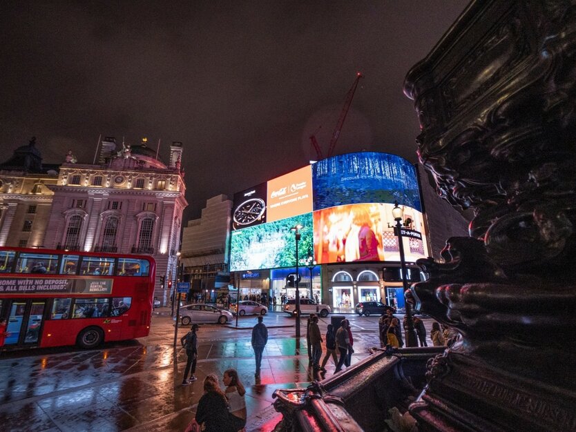London Silvesterreise, Piccadilly Circus beleuchtet bei Nacht, roter Bus, Fußgänger, Brunnen