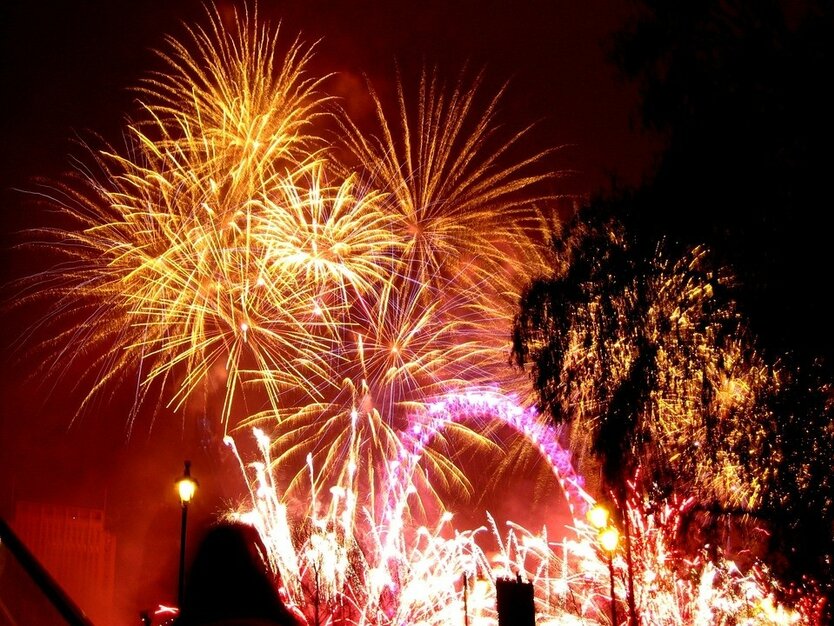 London Silvesterreise, Feuerwerk, Silvesterraketen, bunte Lichter, Bäume, leuchtender Himmel