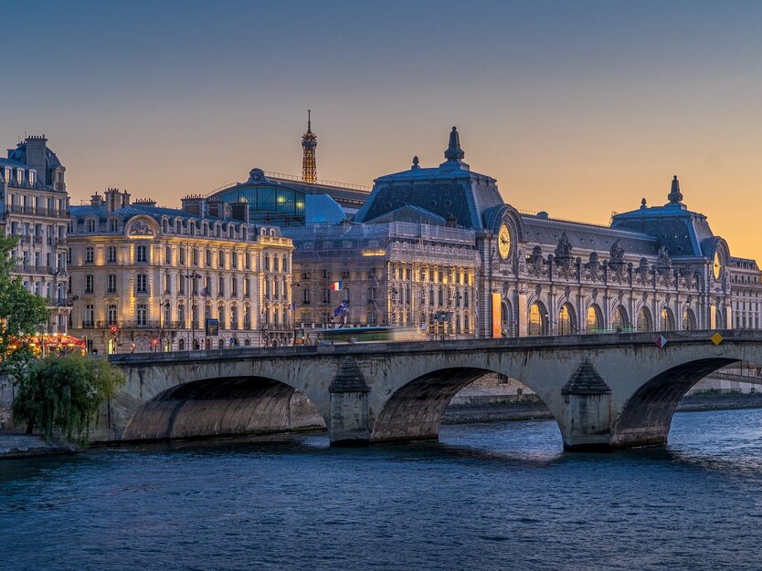 Städtereise Paris, Frankreich, Bootsfahrt, Blick vom Ufer der Seine auf die Seine, brücke, Gebäude und Eiffelturm im Hintergrund, Sonnenuntergang