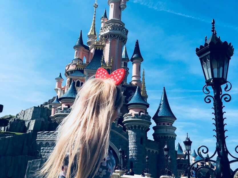 Städtereise Paris, Frankreich, Ausflug Disneyland, Mädchen mit Mickey Mouse Ohren vor dem Disneyland Schloss