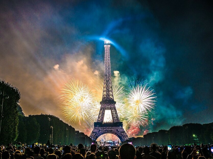 eventreise-paris-frankreich-nationalfeiertag-feuerwerk-eiffelturm-nachts-champs-de-mars-menschen.jpg