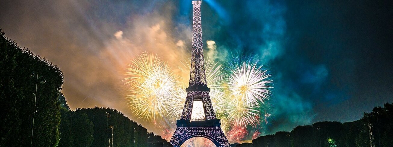 Menschen vor Eiffelturm mit Feuerwerk