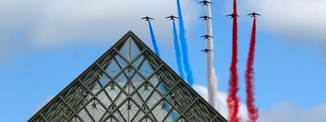 Flugzeuge am Himmel hinter Pyramide vom Louvre mit Abgasen in den Farben der französischen Flagge