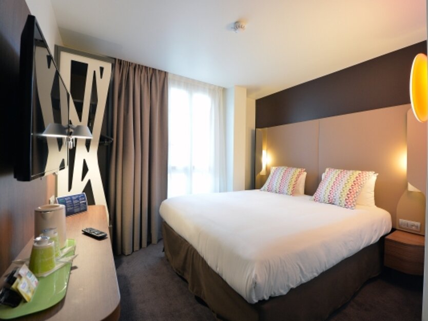 St&auml;dtereise nach Paris Campanile Paris Clichy Hotelzimmer mit Doppelbett und TV