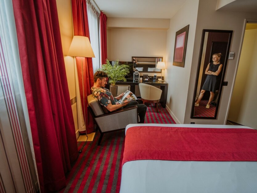 St&auml;dtereise Paris, Frankreich, 4 Sterne Hotel, Hotelzimmer mit Doppelbett, Schreibtisch und einem Gast auf einem Sessel