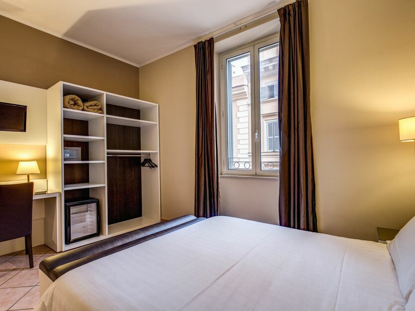 Staedtereise nach Rom in Italien Hotel San Marco Hotelzimmer mit Bett, Schrank und Schreibtisch